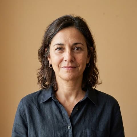 Portrait d’Elena, la cinquantaine, cheveux bruns mi-longs, chemise bleu marine.